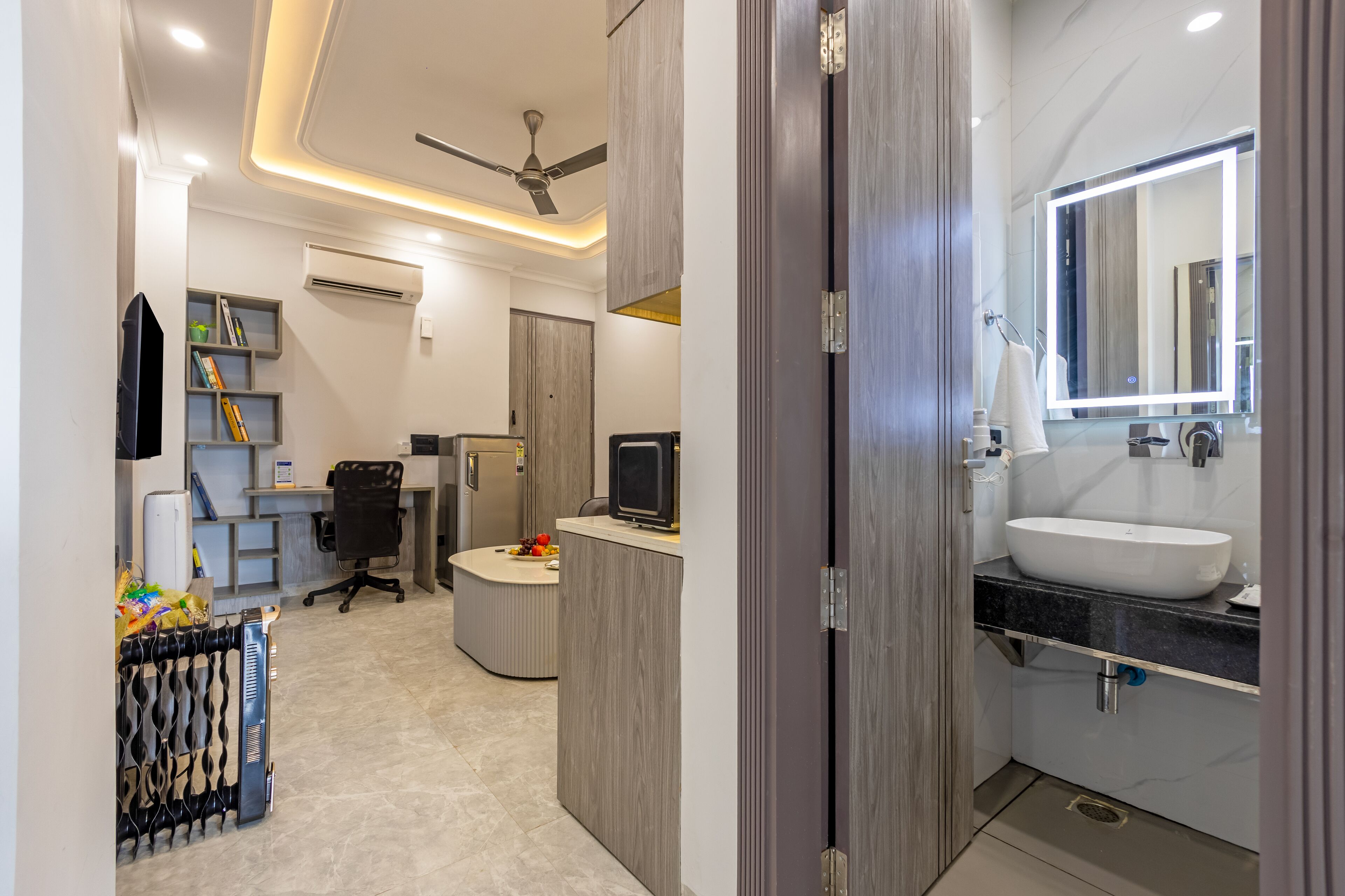 Un baño moderno con un espejo grande, lavamanos y un ventilador de techo.