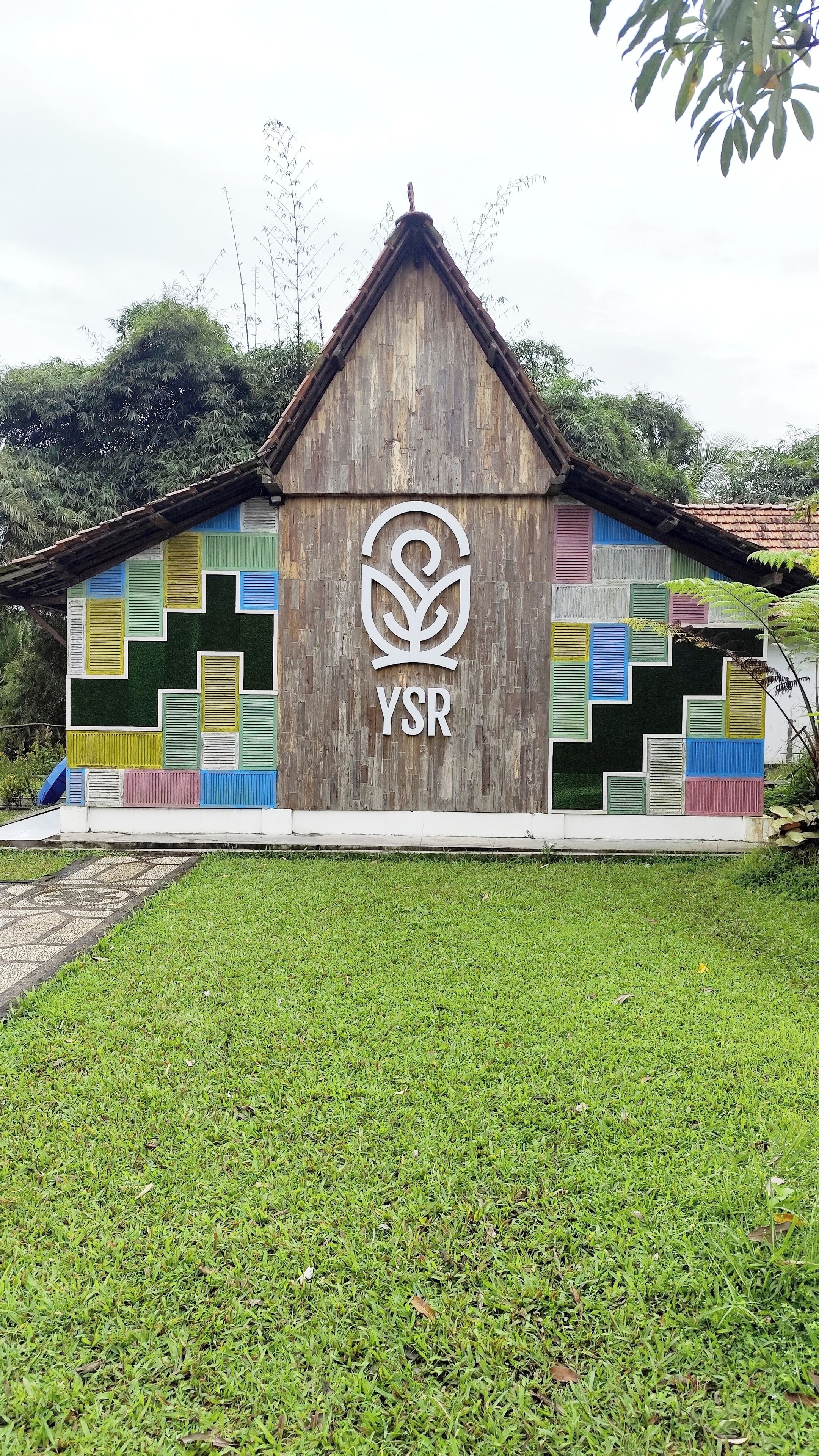 Un bâtiment doté d’une façade en bois et d’un motif géométrique coloré sur le mur.