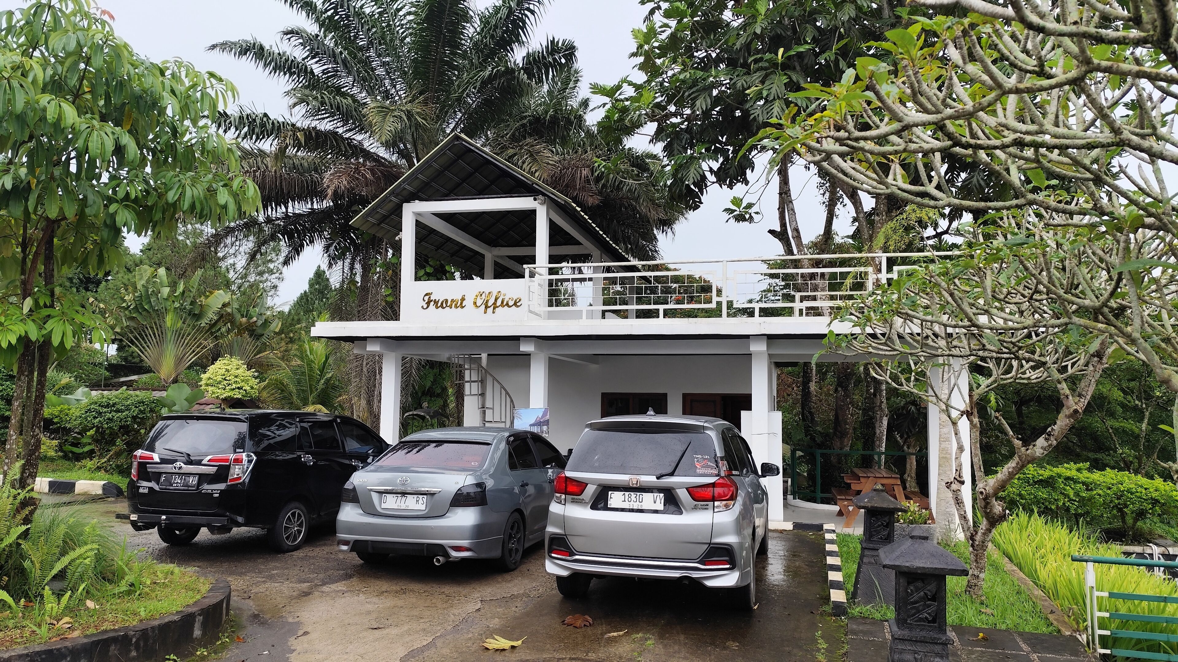 A building labeled "Front Office" with three parked cars in front.