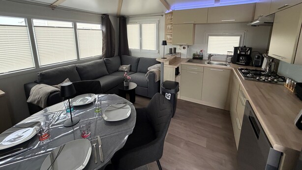 Un espacio habitable compacto con kitchenette, comedor y sofá.