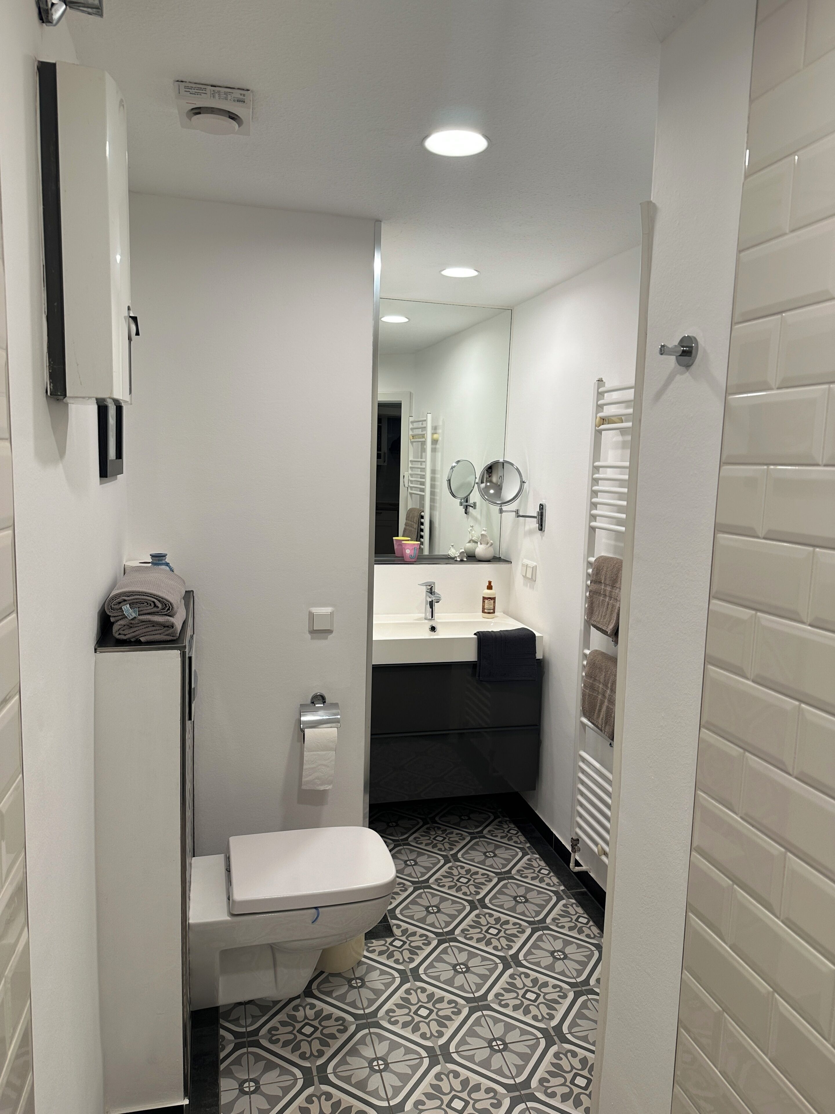 Een kleine badkamer met toilet, wastafel en handdoekhouder.