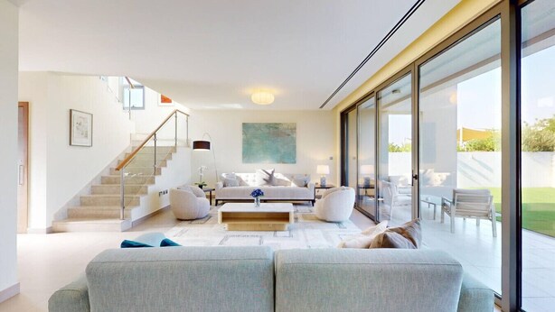 Ein modernes Wohnzimmer mit Treppe, großem Fenster und minimalistischem Design.