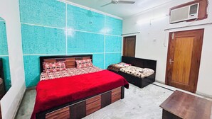 A bedroom with a bed, a bedside table, a wardrobe, and a ceiling fan. - Superb 9-bedroom house with AC in charming Vrindavan (Vrindavan)
