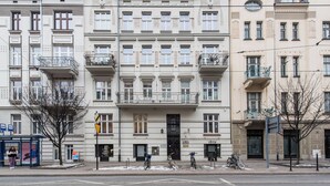 A multi-story building with a central entrance, balconies, and a ground-level shop. - Sun & Snow Rakowicka Residence (Kraków)