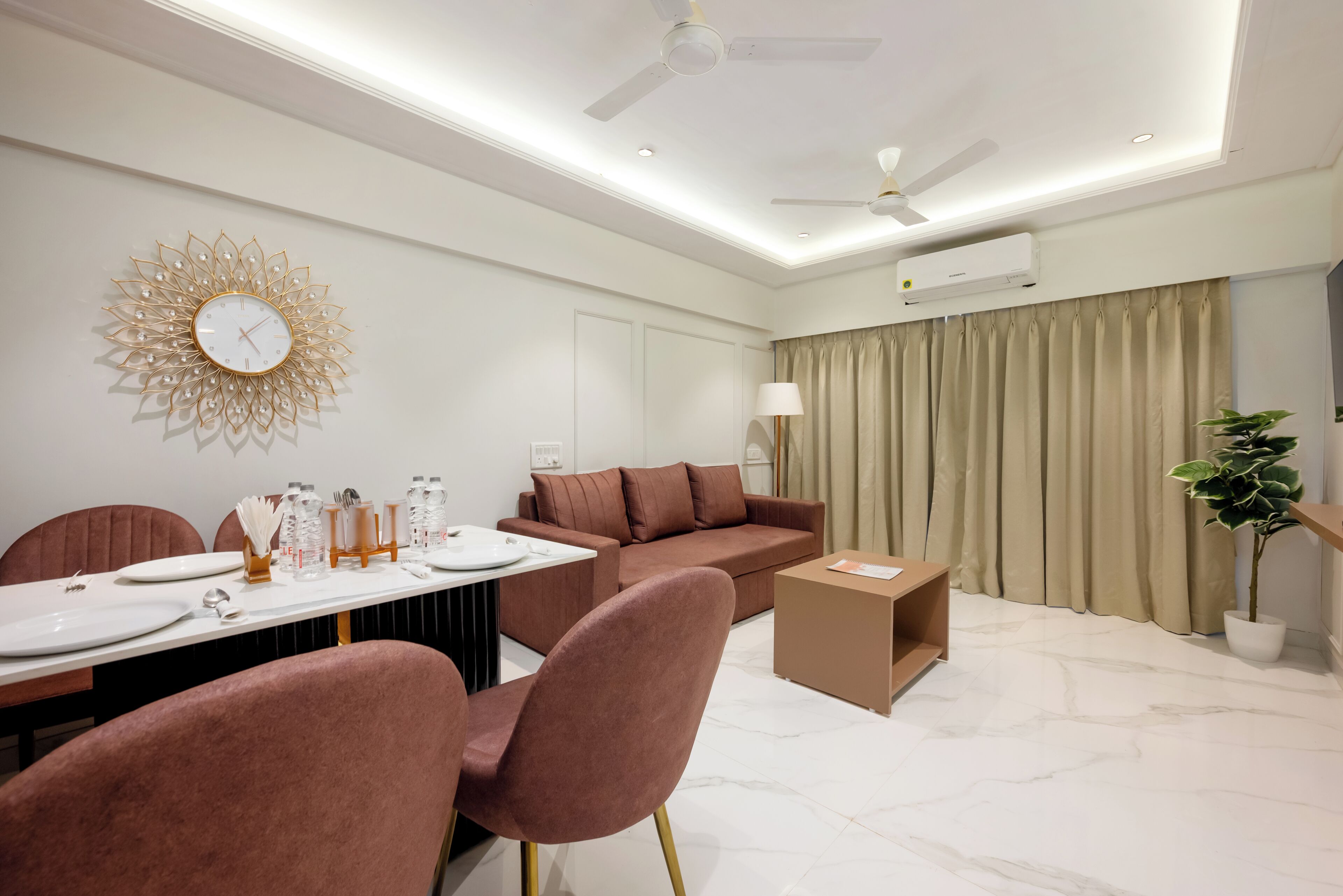 Un salon moderne comprenant un coin repas, un canapé, une table basse et une horloge murale décorative.