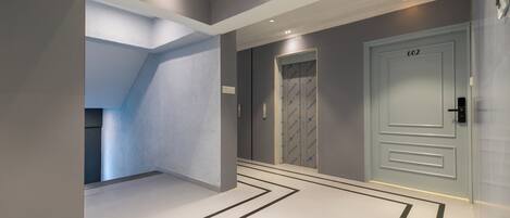A modern hallway with a white floor, grey walls, and a door labeled "602".