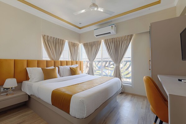 Une chambre d’hôtel équipée d’un lit, d’un bureau, d’un appareil de climatisation et offrant une vue sur l’extérieur.