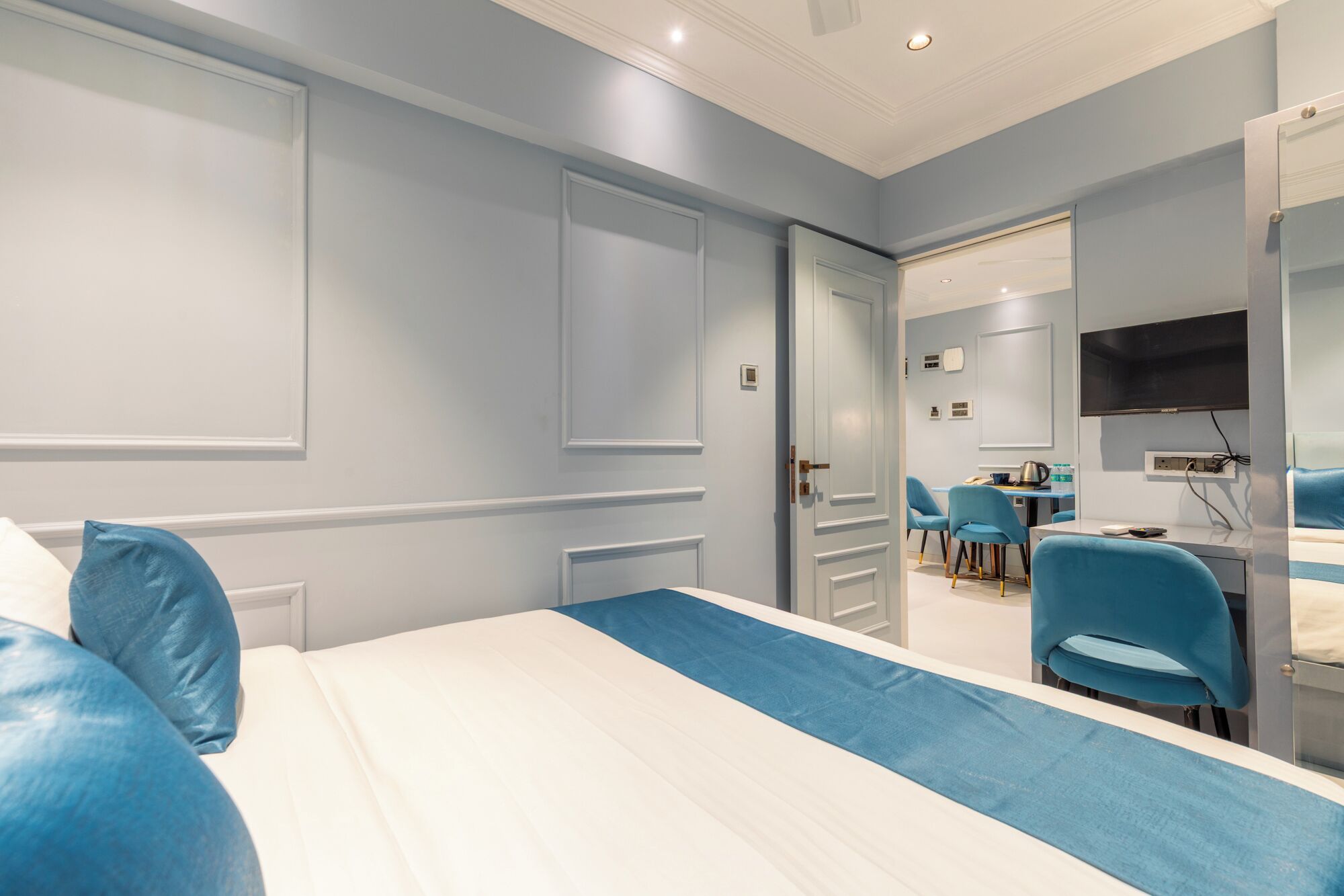 A hotel room with a bed, a desk, and a TV.