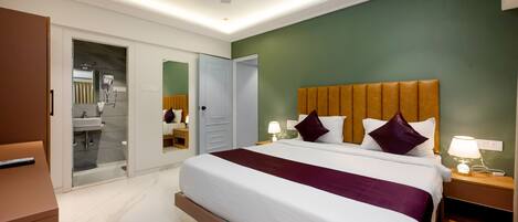 A hotel room with a bed, bedside lamps, a nightstand, a mirror, a wardrobe, and a ceiling fan.