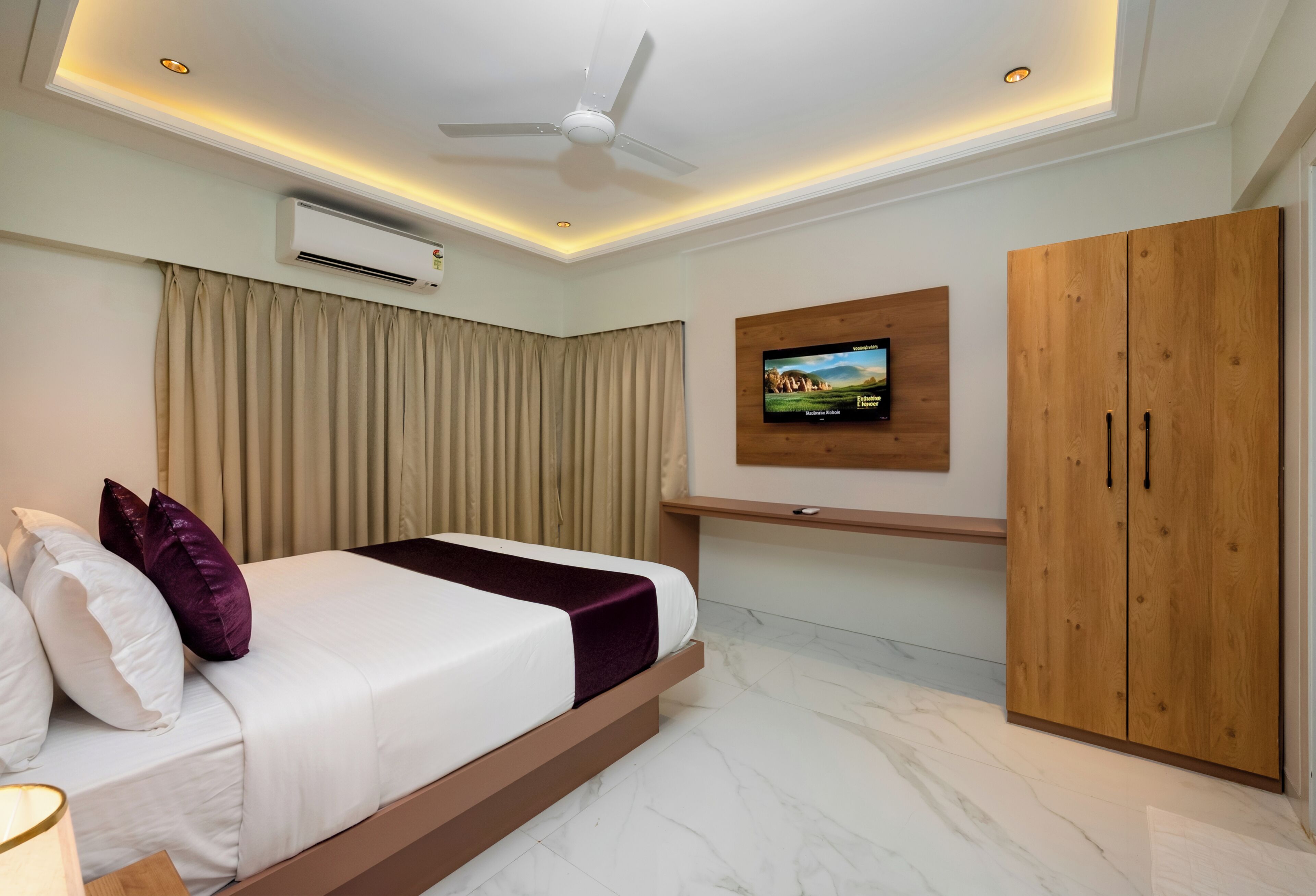 A modern bedroom with a bed, curtains, an air conditioning unit, a ceiling fan, a television, and a wardrobe.