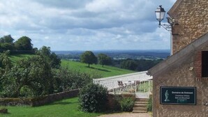 A stone building with a sign for Domaine de Dremont, featuring a view of a white bridge and green fields. - domaine de Drémont (Anthien)