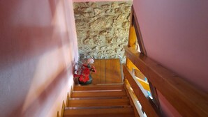 Eine Holztreppe mit einer Steinwand oben.