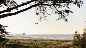 A beach with a pier and a lifeguard tower. - Kallisté - Stunning Oceanview Villa (Île-d'Aix)