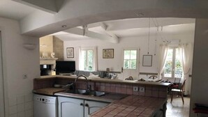 A spacious kitchen with a central island, a dishwasher, and a dining area with a table and chairs. - La Léinade - Spacious Family Villa (Île-d'Aix)
