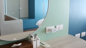 A modern bathroom with a large mirror, a wooden vanity, and a blue accent wall. - J The Park Condotel (Hat Yai)