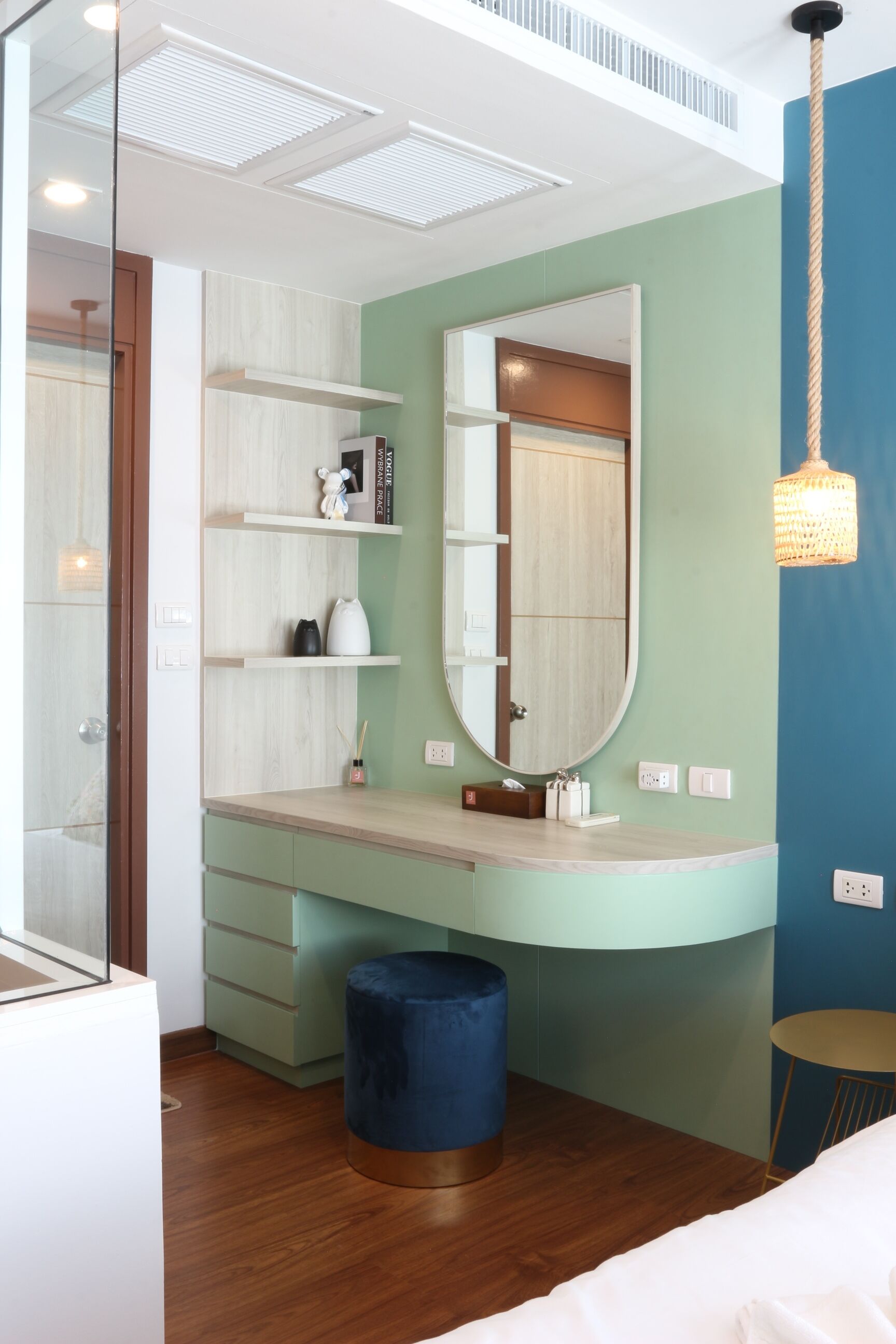 Une salle de bain moderne avec un meuble-lavabo, un miroir, des étagères et un tabouret bleu.