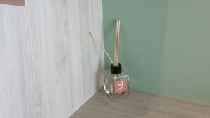 A shelf with two cat-shaped vases and a small bottle with a label. - J The Park Condotel (Hat Yai)