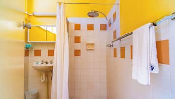A bathroom with a shower, sink, and a towel rack.
