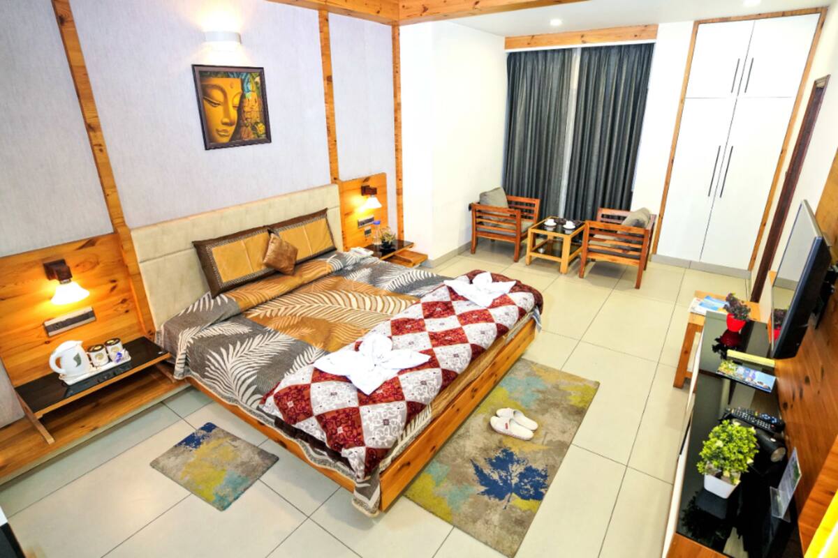A bedroom with a bed, bedside tables, a desk, and a chair.