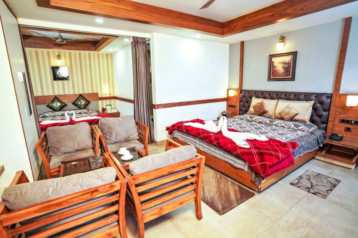 A bedroom with a large bed, wooden furniture, and a mirror.