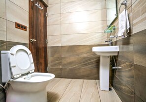 A bathroom with a toilet, sink, and wooden door.