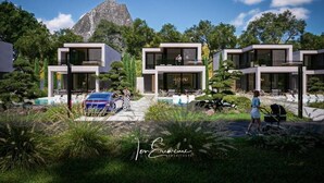 Ein moderner Wohnkomplex mit mehreren zweigeschossigen Häusern, einem Berg im Hintergrund und einer gepflegten Gartenanlage.