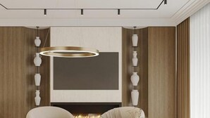 Ein modernes Wohnzimmer mit Kamin, zwei Sofas, einem Couchtisch und einem großen Fernseher.