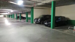 Autotalli, jossa on vihreät pilarit ja useita parkkeerattuja autoja.