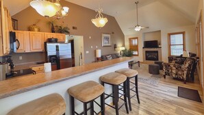 A spacious kitchen with a large island, bar stools, and pendant lighting. - 3BR Condo |  Bayfield Lake Views (Bayfield)