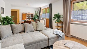En stue med en hjørnesofa, et sofabord og et spiseområde i baggrunden.