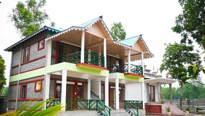 A two-story building with a balcony, a staircase, and a small porch area. - Hotel Dynasty Inn (Mal)