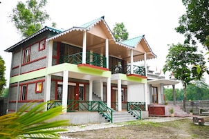 A two-story building with a balcony, a staircase, and a small porch area.
