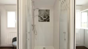 A modern bathroom with a glass-enclosed shower, a wall-mounted toilet, and a window providing natural light. - Gîte "Le Relais De Jehan" with Private Pool, Terrace, and Garden (Saint-Malo des Trois Fontaines)