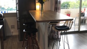 Et moderne køkken med en træø, barstole og en blomstervase.