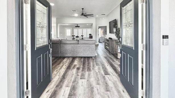 A modern interior with a central seating area, a chandelier, and a ceiling fan. - Twilight Mist - 3/2 in The Village of Poinciana (Poinciana, The Villages)