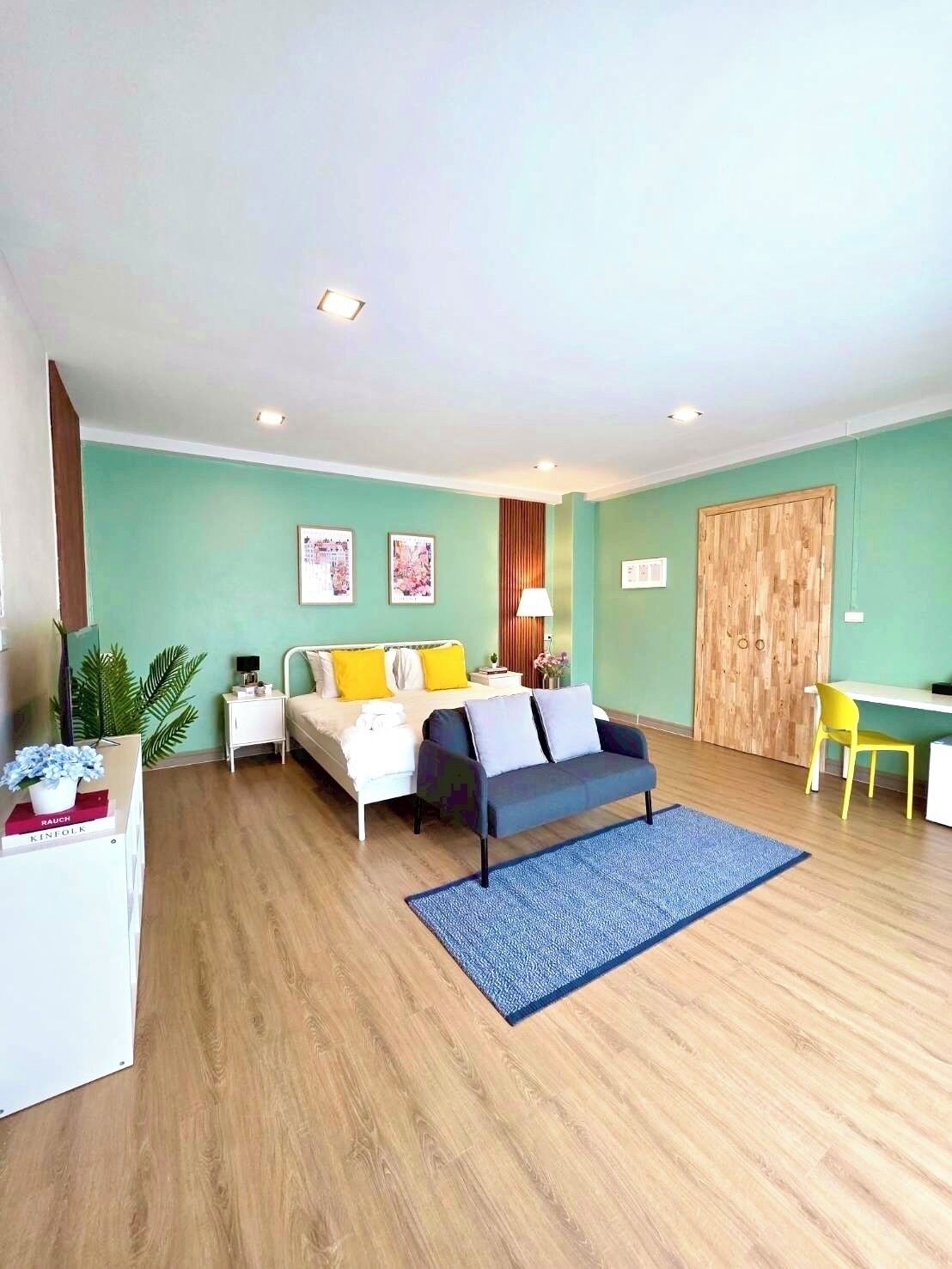 A modern bedroom with a bed, bedside tables, a desk, and a chair.