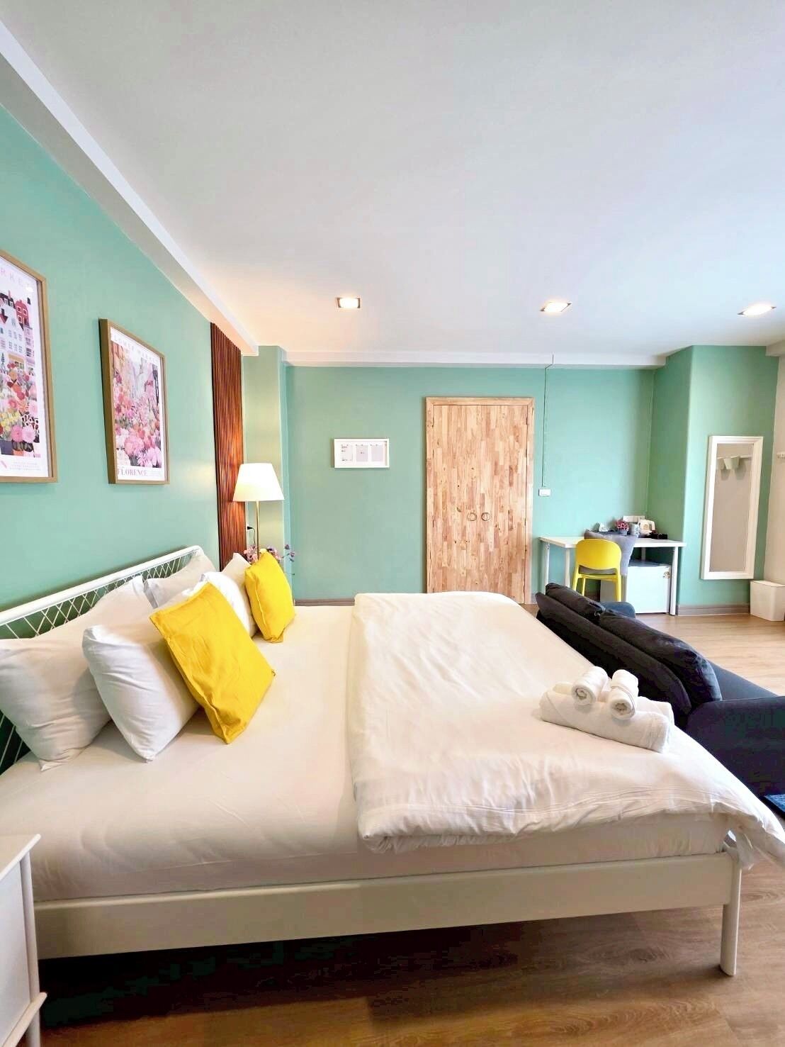 Een netjes ingerichte hotelkamer met een bed, bureau en stoel.