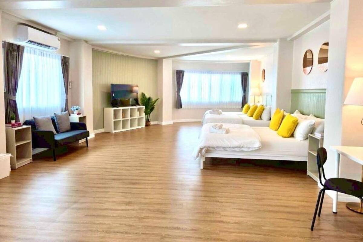 Una habitación de hotel con cama, sofá, televisión y escritorio.
