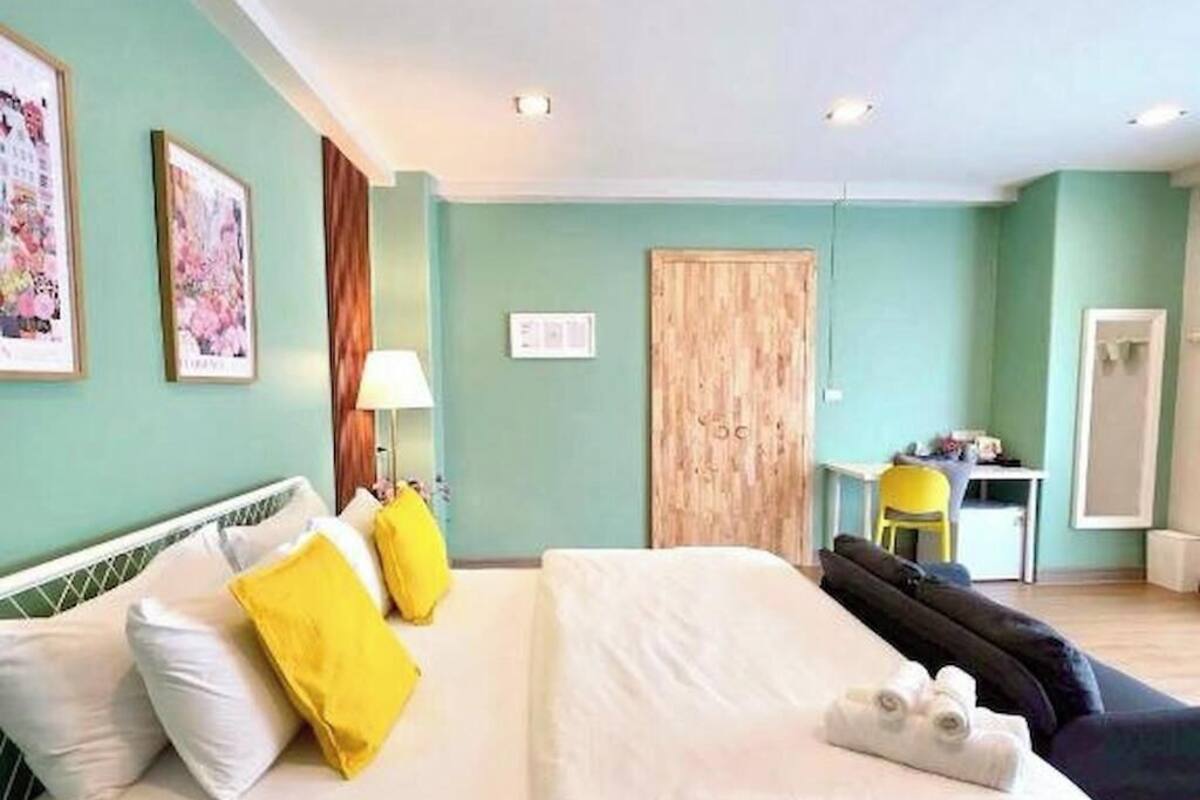 Una habitación de hotel con cama, escritorio, silla y armario.