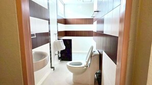 Une petite salle de bain comprenant des toilettes, un lavabo et une baignoire.