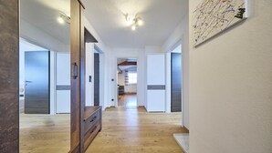 A modern kitchen with white cabinets and a wooden countertop. - Apartment Wenger Leogang (Leogang)