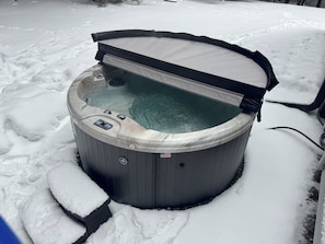 A hot tub partially covered by a canopy, surrounded by snow. - Pines Vignette • Modern 3BR Home in Windham (Windham)
