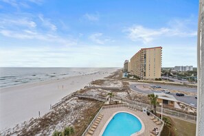 Ein Strandhotel mit Pool, Zugang zum Strand und Parkplatz.
