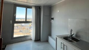 Een moderne keuken met een ingebouwde gootsteen, kasten en uitzicht door een groot raam.