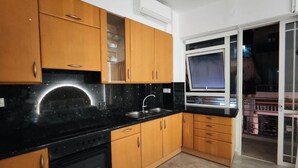 Een moderne keuken met houten kastjes, een zwart aanrecht en een ingebouwde oven.