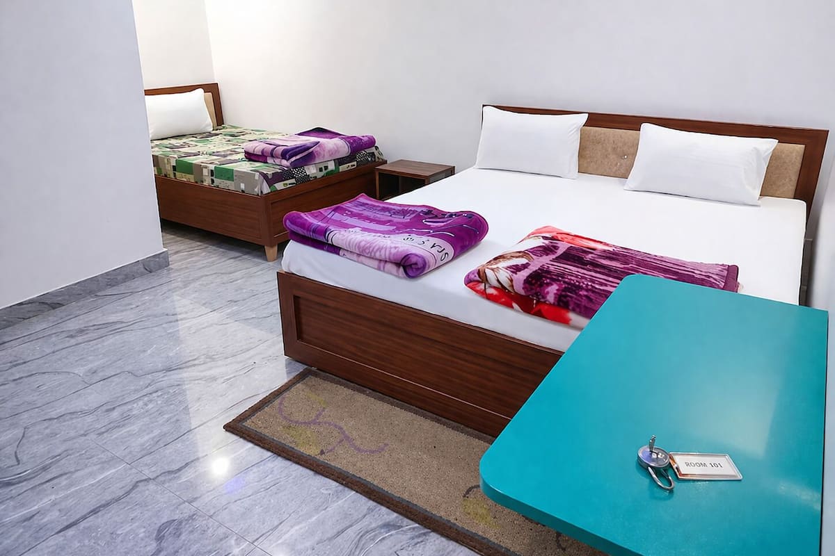 Une chambre d’hôtel avec deux lits, une petite table et une porte portant l’inscription « CHAMBRE 101 ».