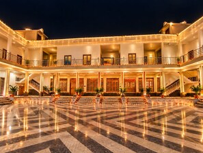 Un vestíbulo de hotel de varios niveles con un espacio central abierto, múltiples escaleras y balcones.