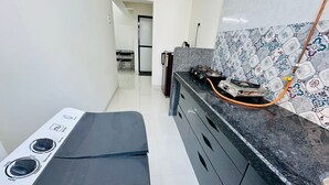 A kitchen with a gas stove, a sink, and a tiled backsplash.