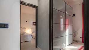 A modern bedroom with a bed, bedside table, and a red-striped rug. - Apartment 'Lido Azzurro Sea Terra' with Mountain View, Wi-Fi and Air Conditioning (Carini)