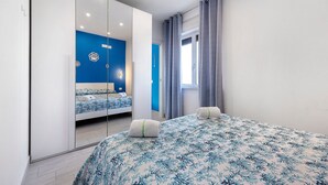 Une chambre à coucher avec un lit, une armoire et une fenêtre avec des rideaux.